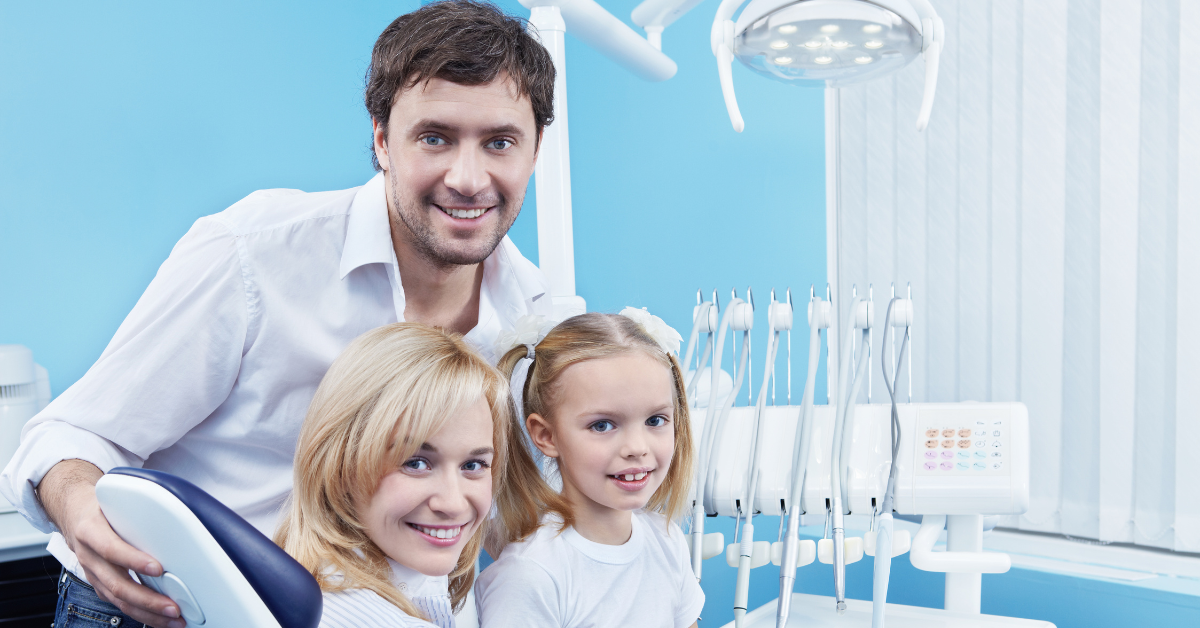 Smiling family at the dentist's office, representing the friendly and welcoming atmosphere at Apple Wellness Dental.