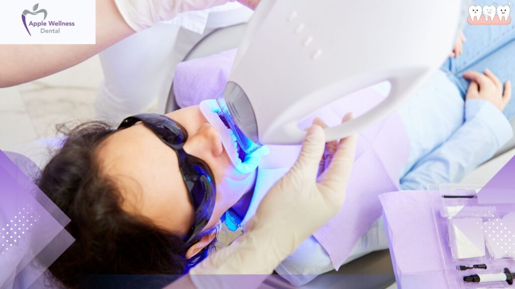 A dentist, clad in a white lab coat, examines a patient's discolored tooth under bright, clinical lighting. The dentist's brow is furrowed in concentration as they peer closely, holding a dental mirror and probe. The patient's face is partially obscured, with only their open mouth visible. The scene is set against a minimalist, sterile backdrop, emphasizing the professionalism and attention to detail of the dental examination. Soft shadows accentuate the dentist's features, creating a serious, contemplative atmosphere as they assess the discoloration and consider the appropriate treatment. Your Guide to How to Treat Teeth Discoloration - Apple Wellness Dental